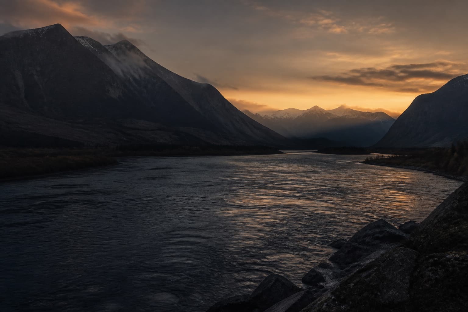 A river moving through a mountain valley at dawn